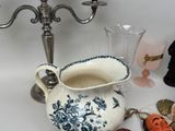 a white and blue vase and a silver candelier on a table