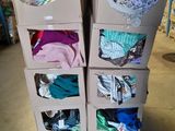 de nombreux cartons de vêtements posés sur une palette dans un entrepôt