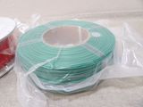 two spools and a spool of red and green spools on a table