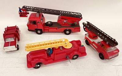 quatre camions de pompiers miniatures et un camion de pompiers posés sur une surface blanche