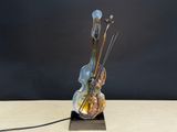a sculpture of a violin and a bow on a table