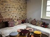 un salon avec un mur en pierre et un grand canapé