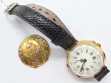 une petite montre et une autre petite montre posées sur une surface blanche