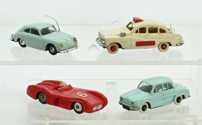 quatre voitures jouets dans une vitrine sur une surface blanche