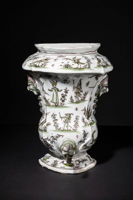 a white vase with green and brown designs on it