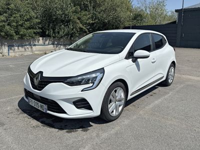 la voiture blanche est garée dans le parking à côté d'un bâtiment