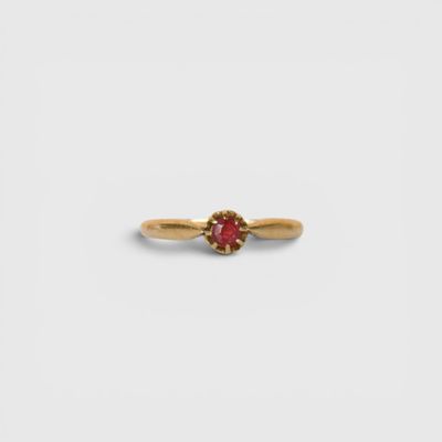 une bague en or avec une pierre rouge au centre