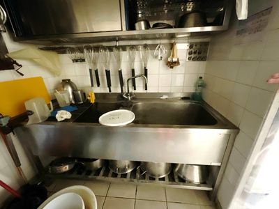 une cuisine équipée d'un évier, d'une cuisinière et de casseroles et poêles