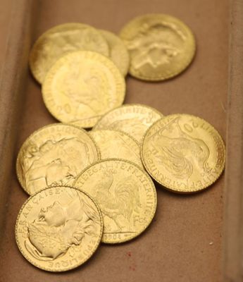 beaucoup de pièces d'or dans une boîte posée sur la table