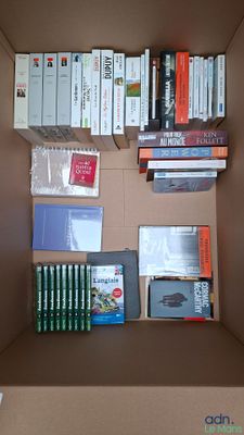 une boîte en carton sur laquelle sont posés de nombreux livres