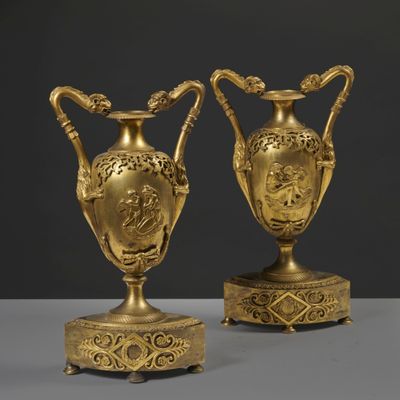 pair of antique brass vases on stands on a table