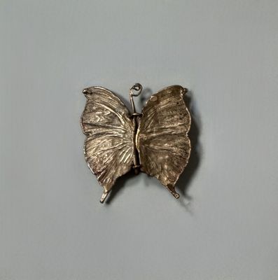 a silver butterfly that is sitting on top of a table