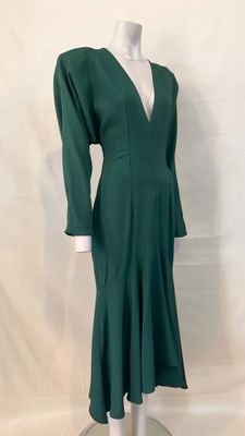 green dress on a mannequin base with a white shirt underneath it
