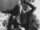 a black and white photo of a woman sitting on a couch smoking a cigarette