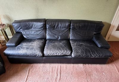un canapé en cuir noir dans un coin du salon