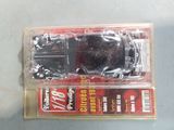a black toy car in a package on a table