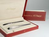 a red box with a pen and a silver pen in it