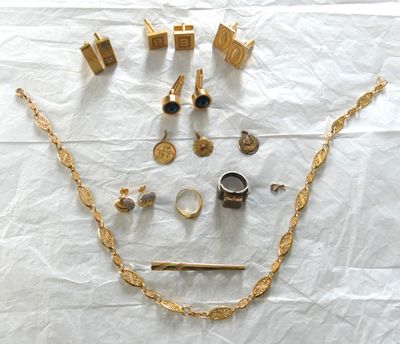 beaucoup de bijoux en or posés sur un drap blanc