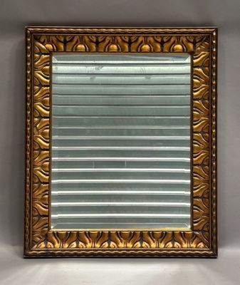 une image représentant un miroir à cadre doré accroché au mur d'une pièce