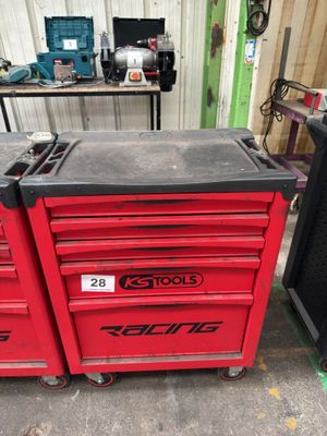 une boîte à outils rouge sur laquelle sont posés des outils, dans un garage