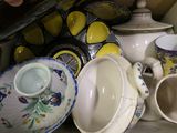 a lot of dishes and cups sitting on a shelf