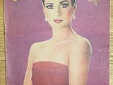 la couverture d'un magazine sur laquelle figure la photo d'une femme en robe rouge