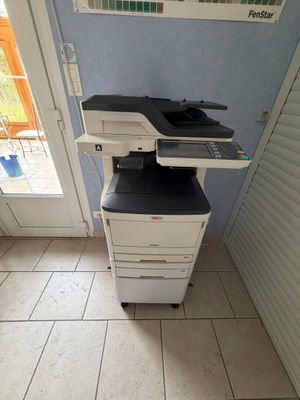 une imprimante posée sur une armoire, dans un coin de la pièce
