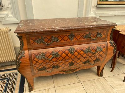 a small chest of drawers in a room with a radiator