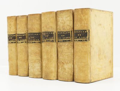 quatre vieux livres sont alignés sur une surface blanche