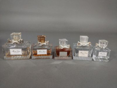 trois flacons de parfum posés l'un à côté de l'autre sur une table