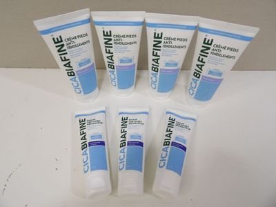 six tubes of toothpaste are lined up on a table