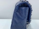 a blue chanel bag on a white table