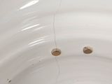 a white bowl with holes in it sitting on a table