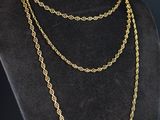 un collier à chaîne en or sur un mannequin, sur fond noir