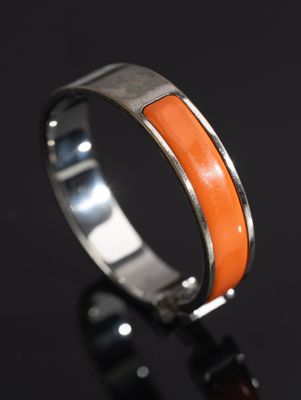 a close up of a ring with an orange stone in it