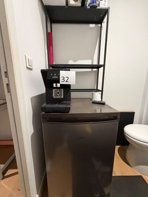 un petit réfrigérateur dans un coin d'une petite pièce