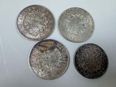 quatre pièces d'argent empilées les unes sur les autres sur une surface blanche