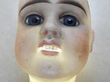 un gros plan sur la tête d'une poupée aux yeux bleus