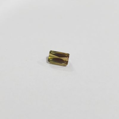 an image of a piece of gold colored glass on a white surface
