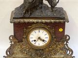 a clock with a statue of a woman and a dog on it