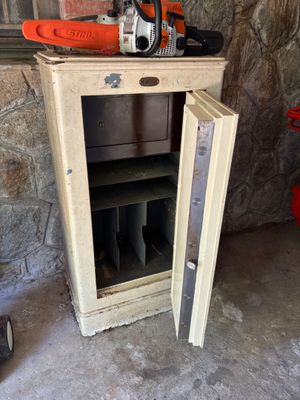 une petite armoire sur laquelle est posée une tronçonneuse