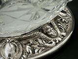 a silver plate with a glass bowl on top of it