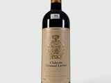 la bouteille de vin rouge est posée sur une surface blanche