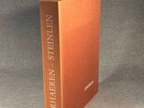 an orange book sitting on top of a table next to a black background