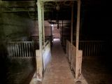 a long hallway leading to a barn with a wooden floor