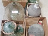 several glass bottles are in a box on a white surface