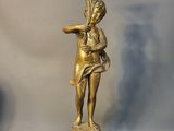 une statue représentant une femme tenant un éventail, posée sur une table