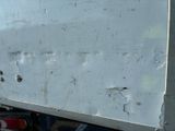 a close up of a white truck with rust on the side