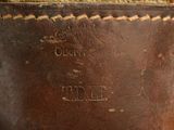 an old brown leather bag with a label on it