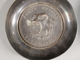 a silver coin sitting next to a silver coin on a table